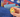 Small pocket hug token being held in front of a school back back with stationary