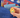 Small pocket hug token being held in front of a school back back with stationary 